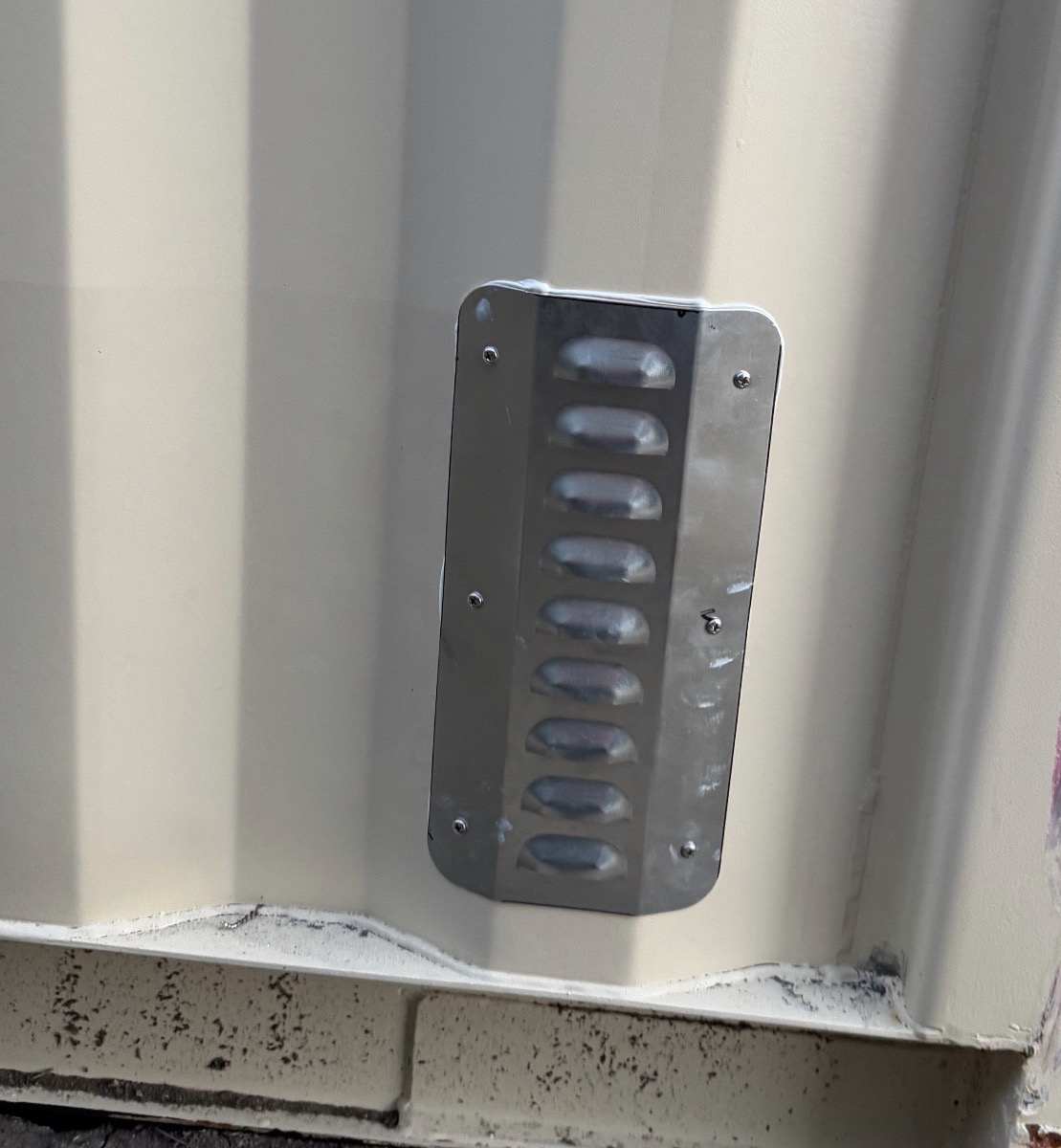 Louvered passive vent on the exterior of a shipping container