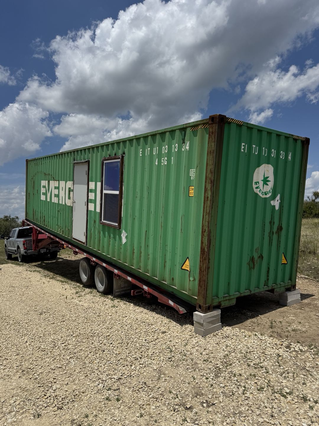 Green shipping container with a window installed on its side