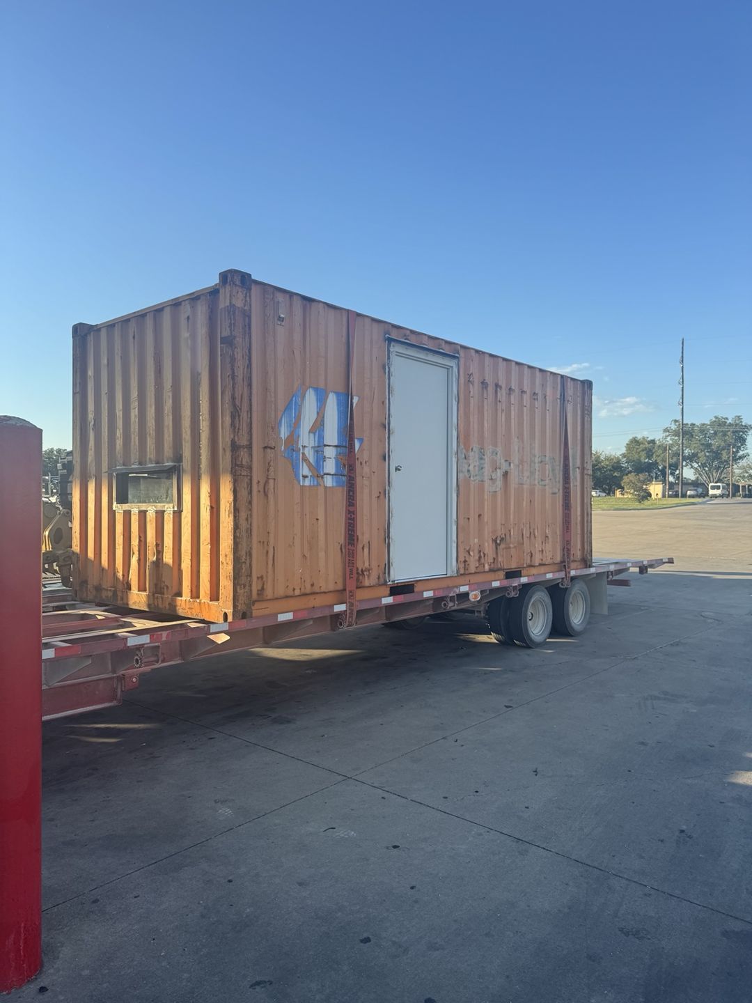 Orange modified container with a steel door and small window