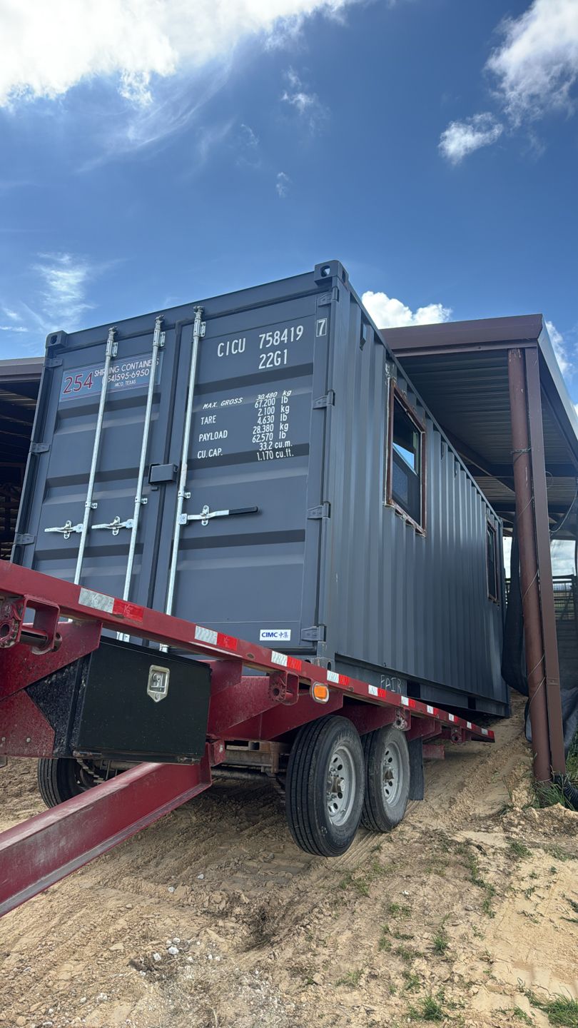 Dark gray container with two side windows on a trailer