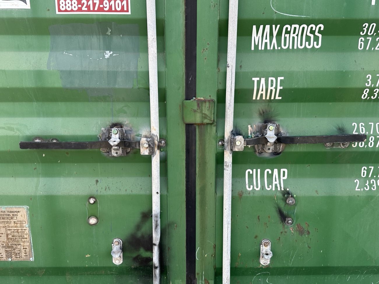 Close view of two metal retrofit handles installed on container door rods