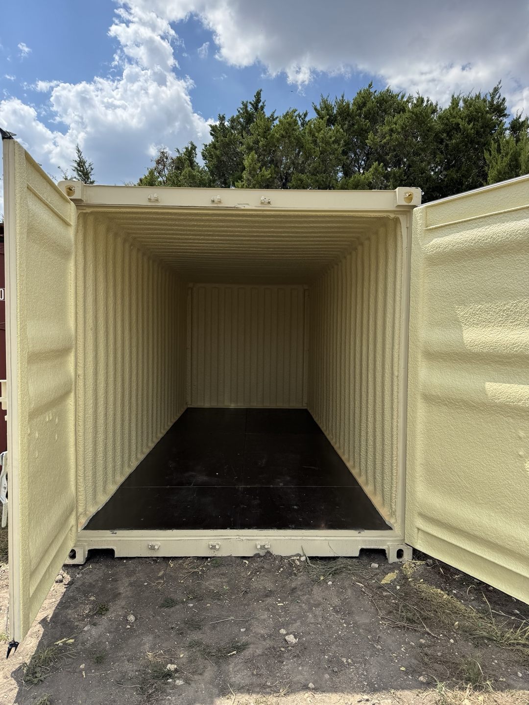 Open doors showing a spray foam coated shipping container interior